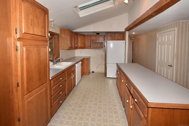 kitchen featuring white appliances, vaulted ceiling with skylight, and sink