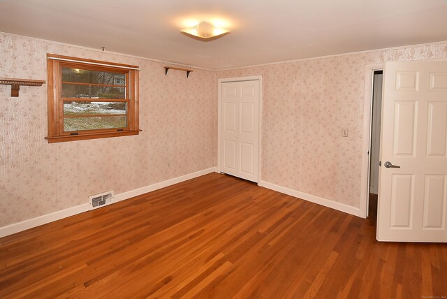 spare room featuring hardwood / wood-style flooring and ornamental molding