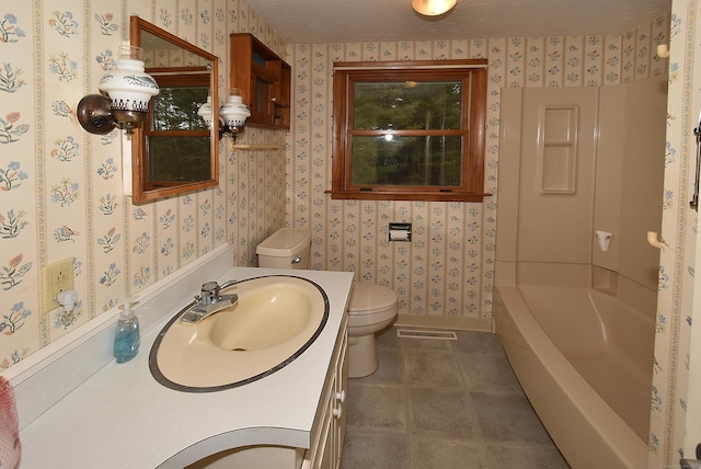 bathroom featuring vanity, toilet, and a bathing tub