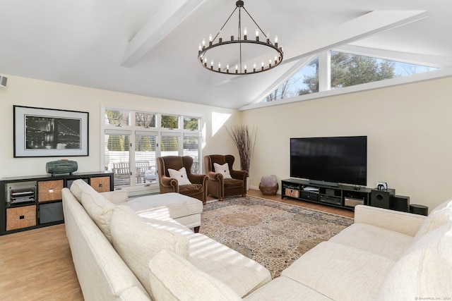 living room with vaulted ceiling with beams, a notable chandelier, and light wood-type flooring