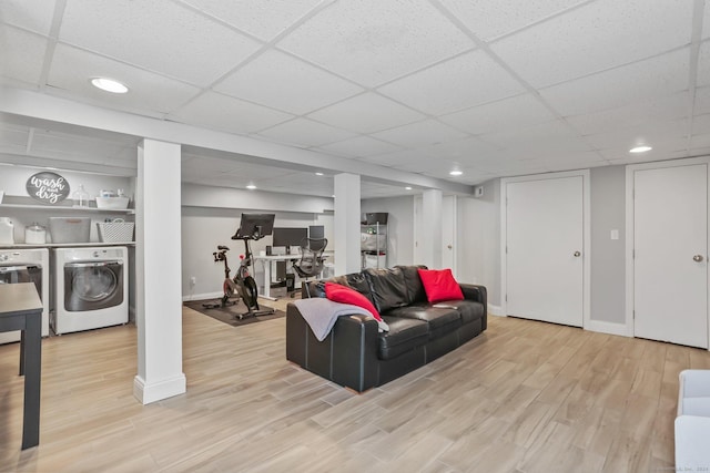 living room featuring a paneled ceiling, washer / clothes dryer, and light hardwood / wood-style floors