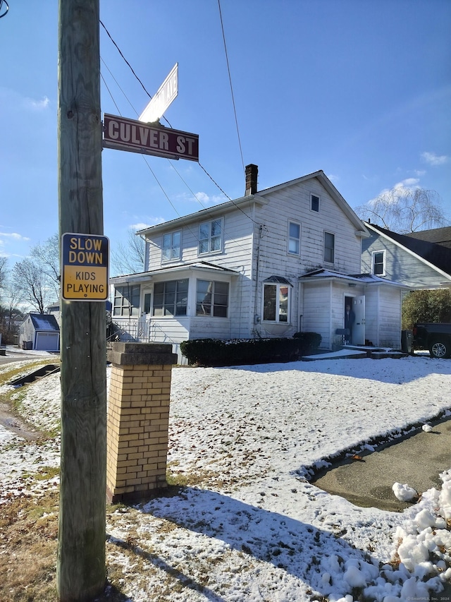 view of snow covered rear of property