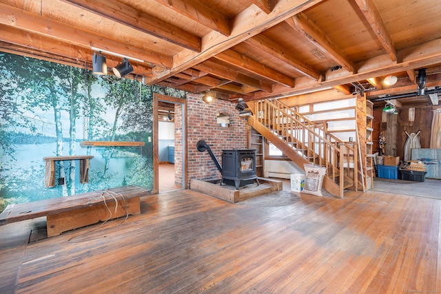 unfurnished living room with hardwood / wood-style floors, a wood stove, and wood ceiling