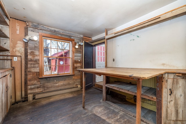 basement with a workshop area, a baseboard radiator, and dark wood-type flooring