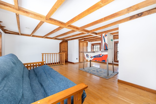 living room featuring beam ceiling and light hardwood / wood-style floors