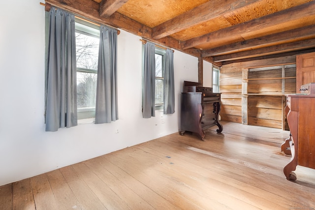 interior space with beam ceiling and light hardwood / wood-style flooring