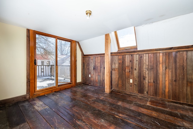 additional living space featuring wood walls, dark wood-type flooring, and vaulted ceiling