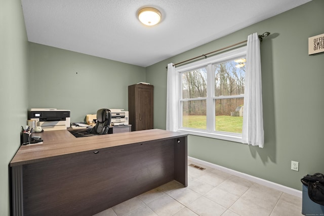 home office featuring light tile patterned floors and a textured ceiling