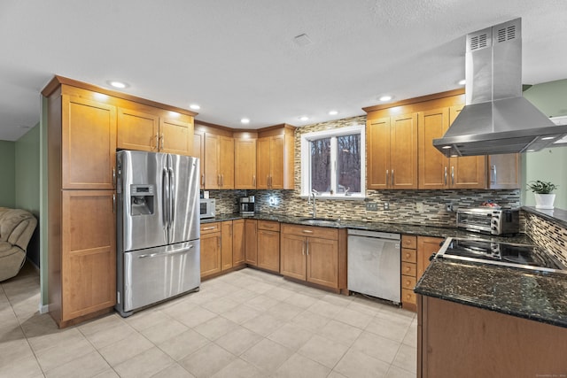 kitchen with sink, stainless steel appliances, dark stone counters, decorative backsplash, and island range hood