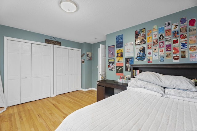 bedroom with hardwood / wood-style flooring and two closets