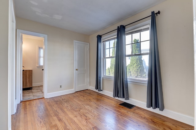 unfurnished bedroom with light hardwood / wood-style flooring and multiple windows