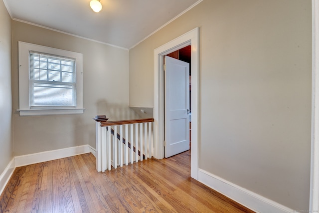 hallway featuring light hardwood / wood-style flooring and crown molding