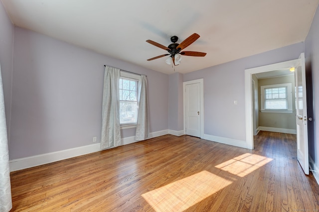 empty room with ceiling fan and light hardwood / wood-style flooring