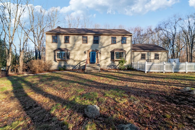 colonial inspired home with a front lawn