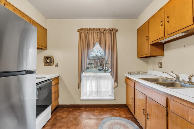 kitchen featuring white stove, dark hardwood / wood-style floors, stainless steel refrigerator, and sink