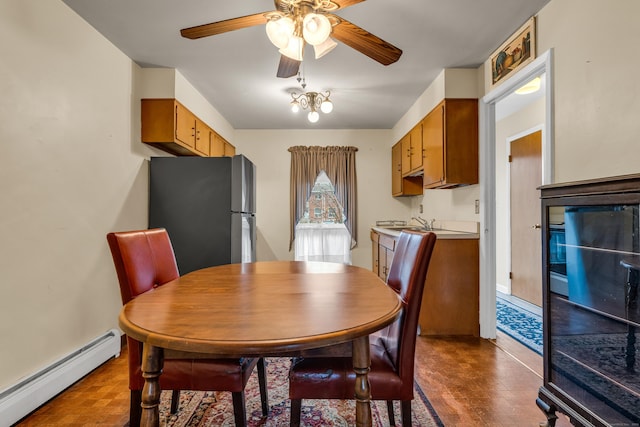 dining space featuring dark hardwood / wood-style floors, ceiling fan with notable chandelier, and a baseboard radiator