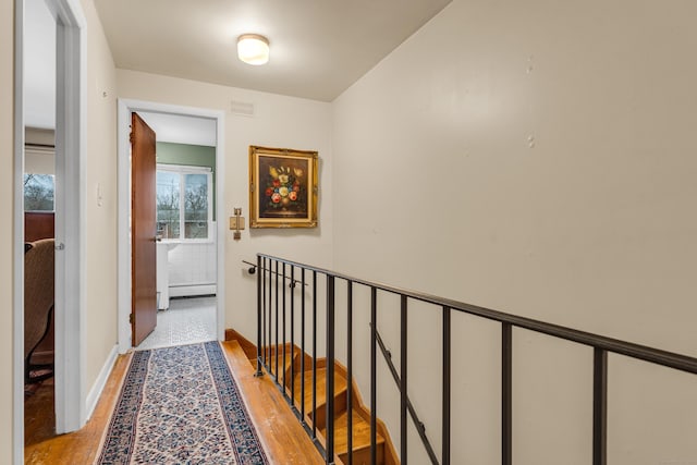 hall with light wood-type flooring and a baseboard radiator