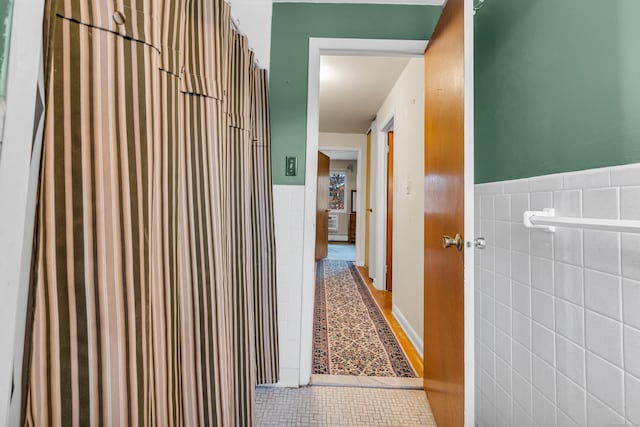 corridor with tile patterned floors and tile walls