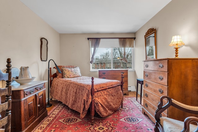 bedroom with hardwood / wood-style floors and baseboard heating