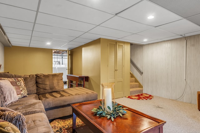 carpeted living room featuring a drop ceiling and washing machine and clothes dryer