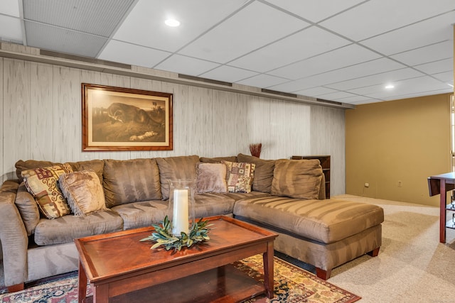 living room featuring a paneled ceiling and light carpet