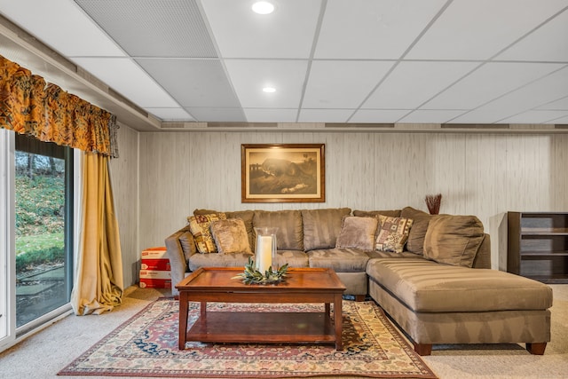 living room featuring carpet and a drop ceiling