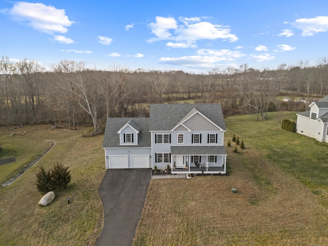 view of front of home featuring a garage, a front yard, and a porch