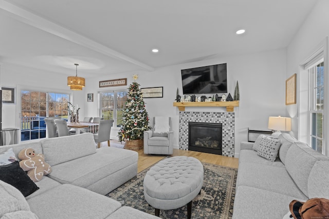 living room featuring a fireplace, wood-type flooring, and beamed ceiling