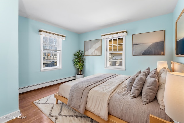 bedroom featuring wood-type flooring and a baseboard radiator