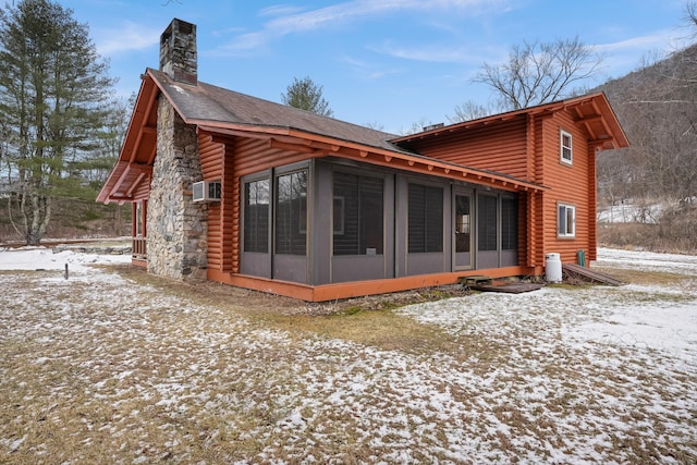 view of snowy exterior with cooling unit and a sunroom