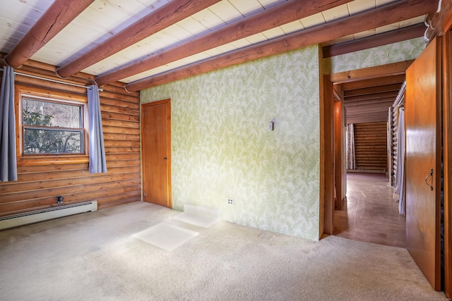 spare room featuring baseboard heating, beam ceiling, rustic walls, and carpet floors