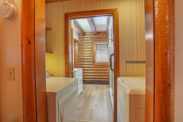 clothes washing area featuring washer and dryer, rustic walls, and light wood-type flooring