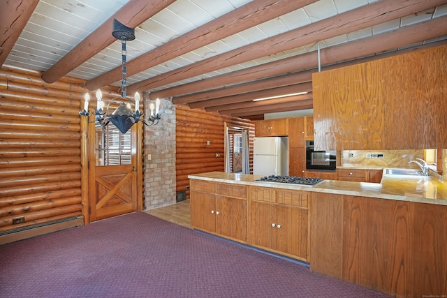 kitchen featuring pendant lighting, sink, white fridge, stainless steel gas cooktop, and kitchen peninsula