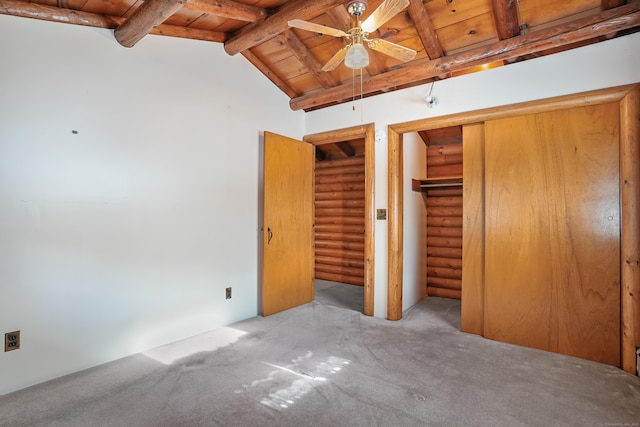 unfurnished bedroom with vaulted ceiling with beams, rustic walls, wood ceiling, light carpet, and a closet