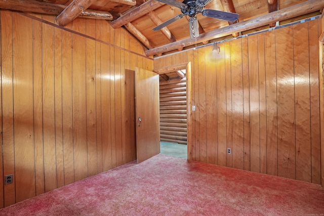 spare room with carpet flooring, vaulted ceiling with beams, ceiling fan, and wood walls