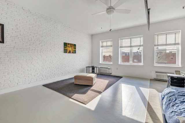 interior space with a wall mounted air conditioner, concrete floors, ceiling fan, and brick wall