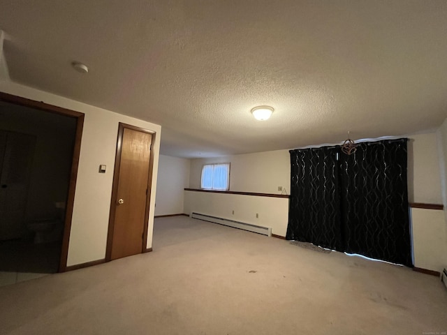 basement with light carpet, a textured ceiling, and a baseboard radiator