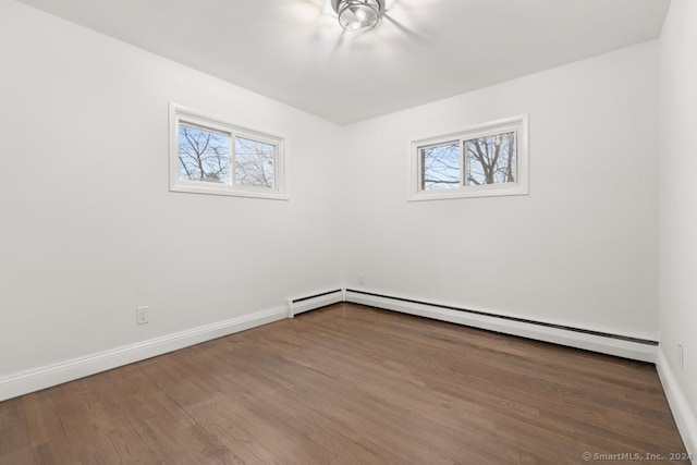 unfurnished room featuring a wealth of natural light, hardwood / wood-style floors, and a baseboard radiator