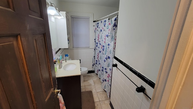 bathroom with tile patterned floors, vanity, tile walls, and toilet