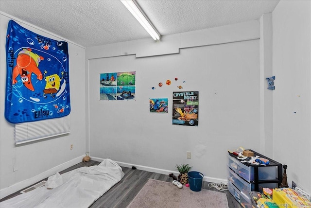 bedroom with a textured ceiling and hardwood / wood-style flooring