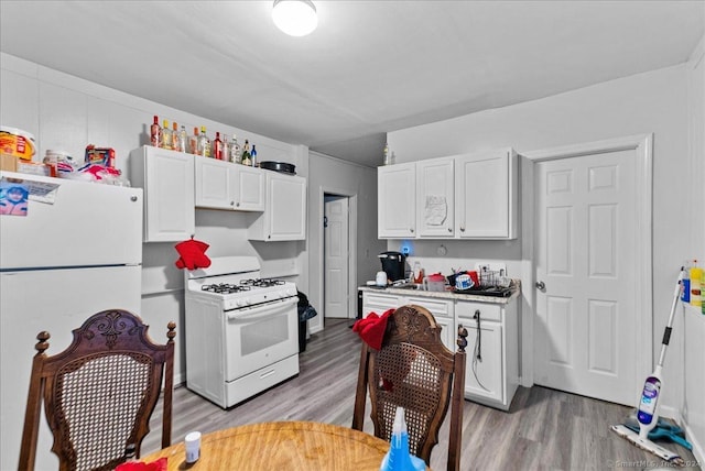 kitchen with white appliances, light hardwood / wood-style flooring, and white cabinetry