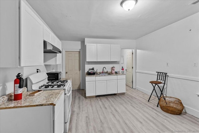 kitchen with sink, light hardwood / wood-style flooring, white cabinets, white gas stove, and range hood