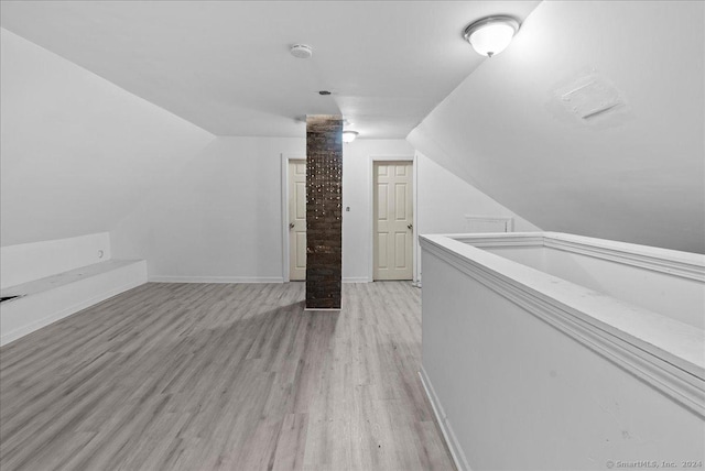 additional living space featuring light hardwood / wood-style floors and lofted ceiling