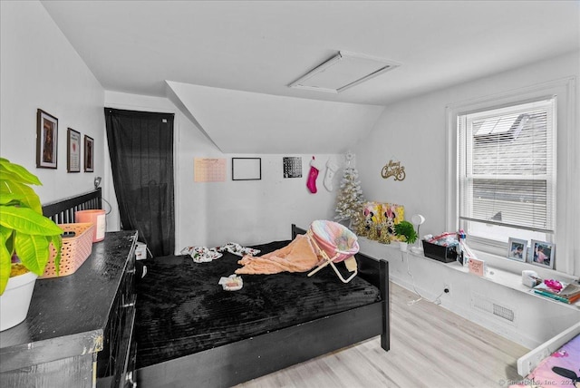 bedroom featuring light hardwood / wood-style floors and vaulted ceiling