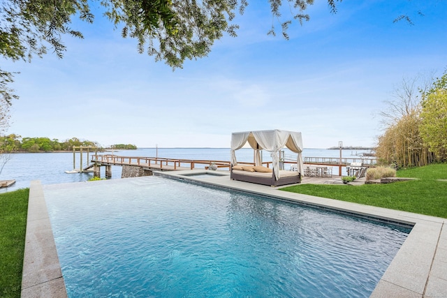 view of pool featuring a yard, a water view, and a dock