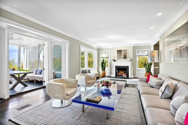 living room with wood-type flooring, crown molding, and a wealth of natural light