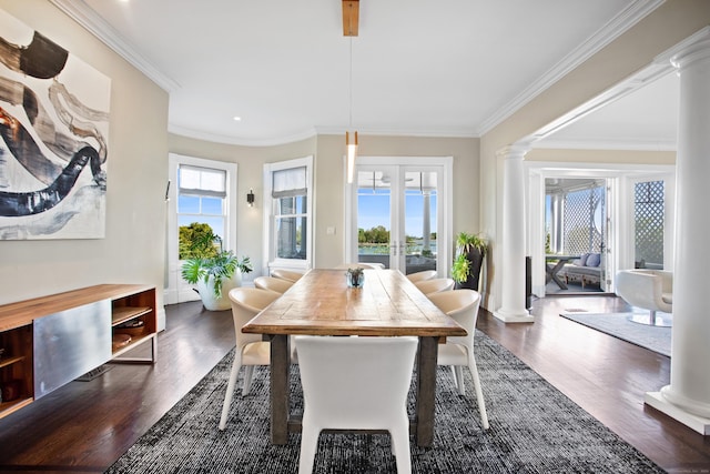 dining area with decorative columns, crown molding, and dark wood-type flooring