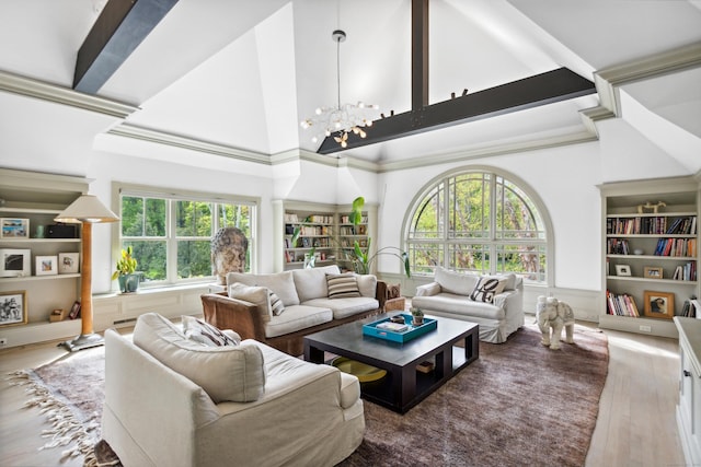 living room featuring plenty of natural light, hardwood / wood-style floors, a high ceiling, and an inviting chandelier