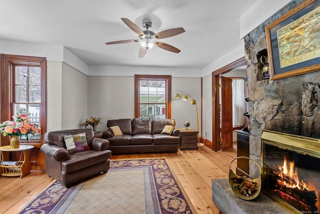 living room with a fireplace, hardwood / wood-style flooring, a wealth of natural light, and ceiling fan