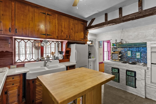 kitchen featuring tasteful backsplash, ceiling fan, sink, and white refrigerator